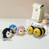 Complete bee and penguin crochet plush set supplies on wooden table