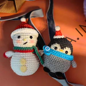 Complete christmas penguin snowman crochet kit supplies on wooden table