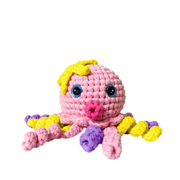 Small crochet pink octopus plush placed on a modern office desk