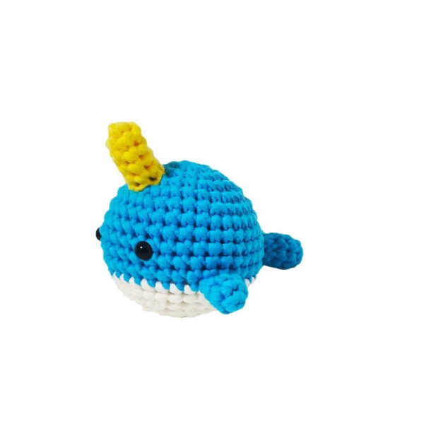 Small crochet narwhal plush placed on a modern office desk