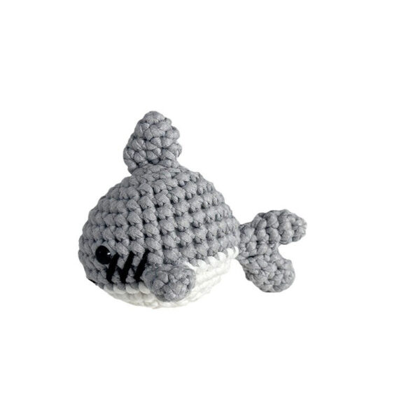 Small crochet gray shark plush placed on a modern office desk