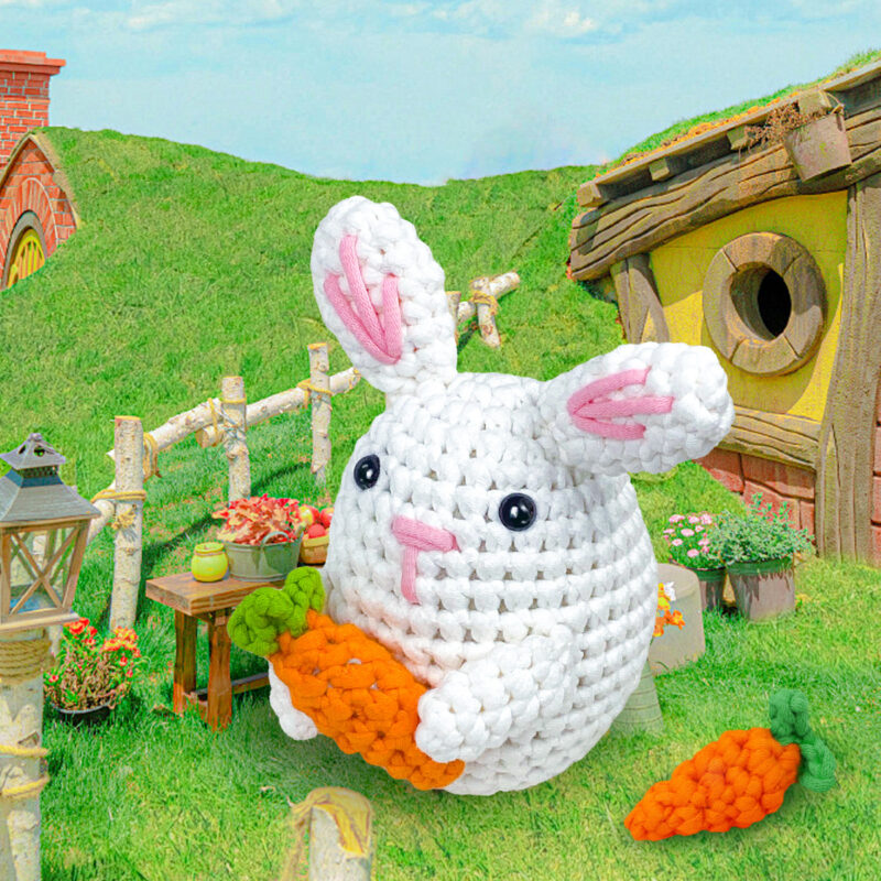 Finished handmade white bunny with carrot crochet plush displayed on shelf